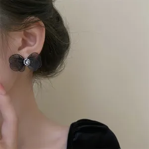 Élégantes boucles d'oreilles nœud papillon en maille noire avec perles et strass.