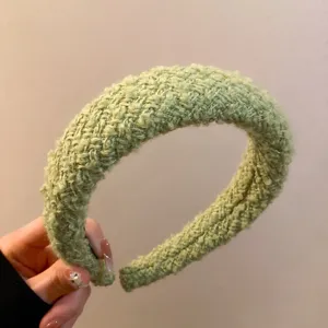 Vista dettagliata della fascia in peluche tessuta verde, primo piano del cerchietto per capelli.