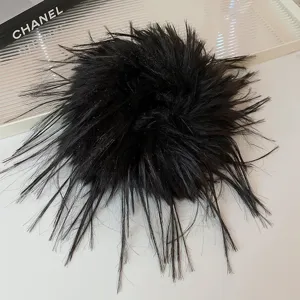 Vista dettagliata del mollettone per capelli con piume nere, accessorio soffice per donne.