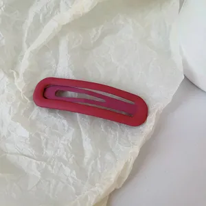 Détail de pince à cheveux mate rouge, design minimaliste mignon pour un usage quotidien.