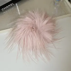 Primo piano dettaglio del fermaglio per capelli in piuma rosa soffice ed elegante.