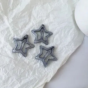 Gros plan de trois pinces à cheveux étoiles argentées scintillantes avec un design snap, accessoires.