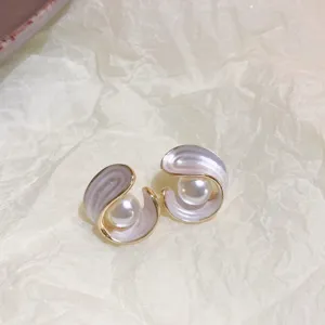 Elegant pearl earrings with gold rim and swirl design, trendy and stylish jewelry accessory.