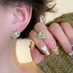 Close-up detail of the stylish irregular green heart stud earring and matching ring jewelry set.