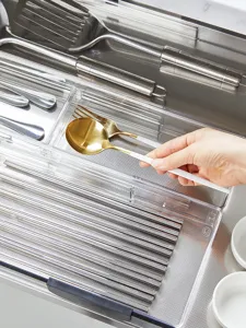 Detailed view of transparent kitchen drawer organizer box, perfect for sorting cutlery and spoons.