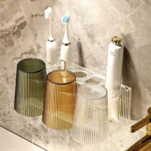Set portaspazzolino e bicchiere collutorio in acrilico trasparente con design a righe.