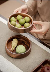 Détail de l'assiette à snack en bois avec texture de noyer et design rond pour le thé.