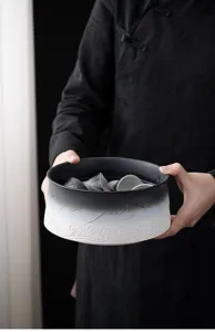 Close-up detail of a ceramic tea wash basin with gradient black and white wave patterns.