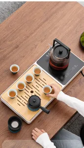 Set da tè automatico con bollitore elettrico e vassoio in legno vista dettagliata.