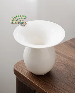 Exquisite ceramic tea strainer detail featuring a colorful peacock handle for brewing.
