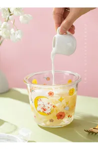 Vue détaillée du bol en verre mignon avec lapin, scène de versement de lait frais et déco.