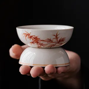 Ceramic kung fu tea strainer with red bamboo pattern, elegant tea set accessory for infusing tea.