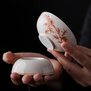 Hand-painted ceramic tea strainer holder with red bamboo pattern for kung fu tea ceremony.