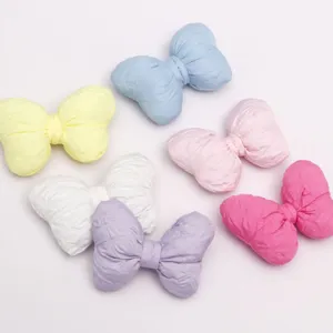 Vista dettagliata di fiocchi in cotone imbottito colorato con tessuto plissé 3D per accessori.