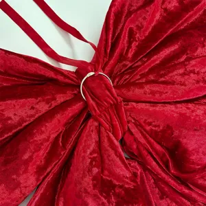Primo piano dettagliato di un grande fiocco in velluto rosso con anello metallico e spalline.