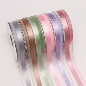 Primo piano di rotoli di nastro in raso e organza colorati, perfetti per confezionare bouquet e decori.