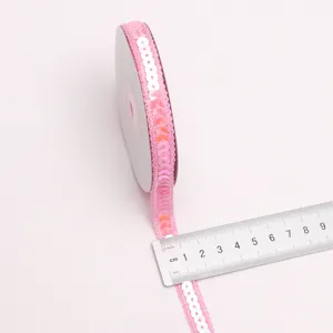 Detalle de cinta de lentejuelas onduladas rosas, accesorio brillante para manualidades y decoración.