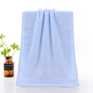Blue cotton face towel with elegant floral embroidery border, soft and absorbent daily use.