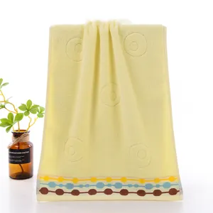 Yellow cotton face towel with embossed circles and colorful striped border design for home.