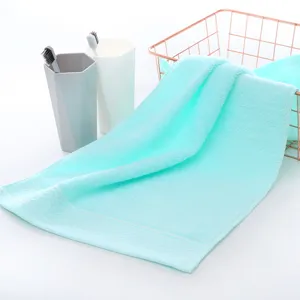 Nahaufnahme eines weichen mintgrünen Baumwollhandtuchs mit feinem gewebten Bordürendesign für Zuhause.