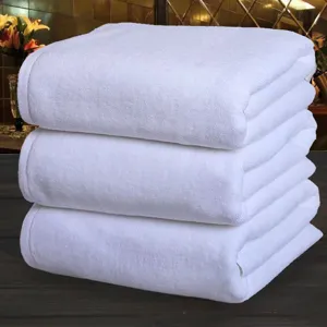Detailed view of stacked white cotton towels, soft texture for hotel and home daily use.