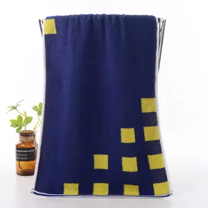 Detailed view of dark blue cotton face towel featuring stylish yellow square geometric patterns.