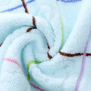 Primo piano di asciugamano per bambini in cotone morbido, dettaglio texture a quadri blu.