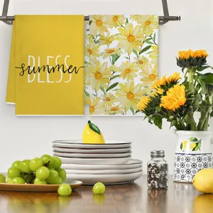 Kitchen towel detail showing watercolor daisy and yellow summer text design in home setting.