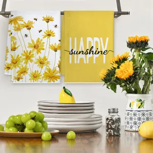 Detailansicht von Küchenhandtüchern mit Sonnenblumen und Bienen, saugfähig und weich im Dekor.