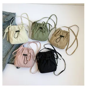 Nylon drawstring bucket bag for women, simple casual crossbody shoulder bag with adjustable strap.