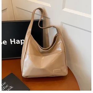Dettaglio borsa a spalla hobo in pelle verniciata beige, grande shopper con tasca frontale.
