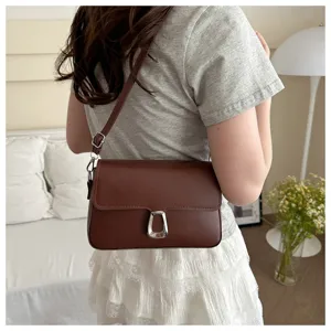 Detail shot of retro brown PU leather crossbody bag with metal lock, chic shoulder style.
