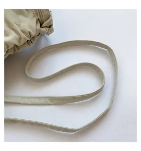 Detailed close-up of stylish nylon shoulder bag strap with elegant drawstring gathering.