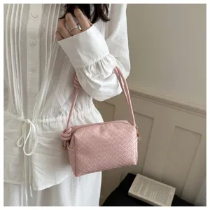 Detailed view of a stylish pink woven leather shoulder bag showcasing exquisite craftsmanship.