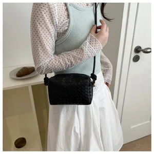 Classic black woven leather crossbody camera bag detail showing stylish intrecciato pattern.