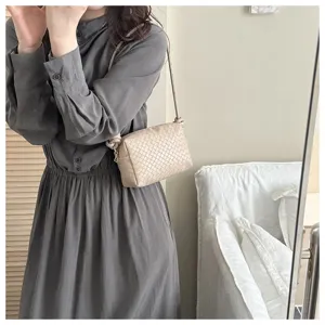 Detailed view of beige woven crossbody camera bag, premium leather texture, chic everyday style.