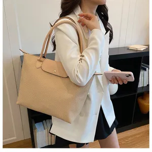 Stylish woven tote bag featuring leather flap and dual handles, perfect for daily commuting use.