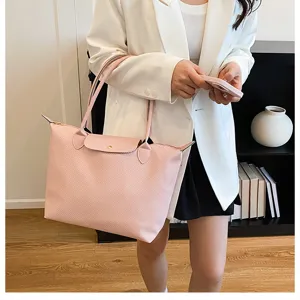 Pink nylon tote bag with leather flap and double handles for women daily commute style.