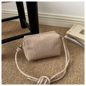 Woven leather crossbody camera bag detail, neutral tone shoulder bag with knot strap