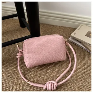 Chic woven leather crossbody camera bag for women, stylish pink shoulder bag with knot.