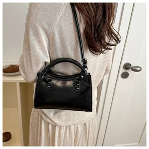 Detailed view of a trendy black patent leather retro handbag, perfect for daily commuting and stylish look.