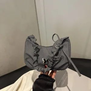 Denim ruffle shoulder bag detail showing the unique silver butterfly metal hardware and fabric texture.