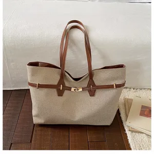 Vintage large capacity canvas shoulder tote bag with brown leather trim and metal lock closure.