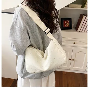 Gedetailleerd uitzicht op een trendy witte sterrenpatroon schoudertas met verstelbare riem.