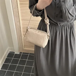Chic woven crossbody camera bag featuring stylish knot strap design for daily fashion.