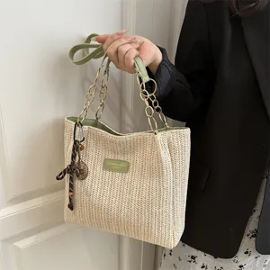Casual straw woven tote bag with green chain handle and chic design for holiday travel.