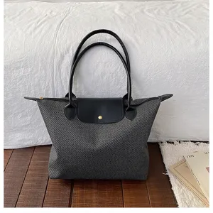 Detailed shot of the woven tote bag on wooden floor with fabric background, elegant texture.