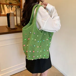 Green crochet shoulder tote bag for women, featuring colorful pearl details. Stylish beach bag.