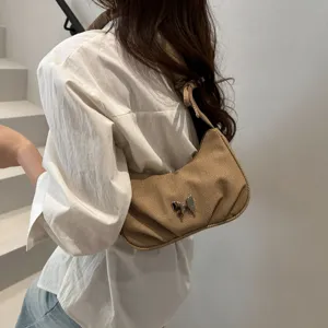 Brown pleated shoulder bag with metal butterfly detail, stylish casual armpit bag design.