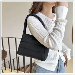Detail shot of a black quilted nylon shoulder bag, casual daily underarm style for women.